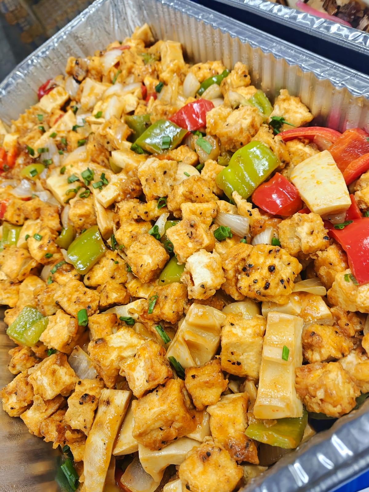 Tray of chili paneer with peppers and onions